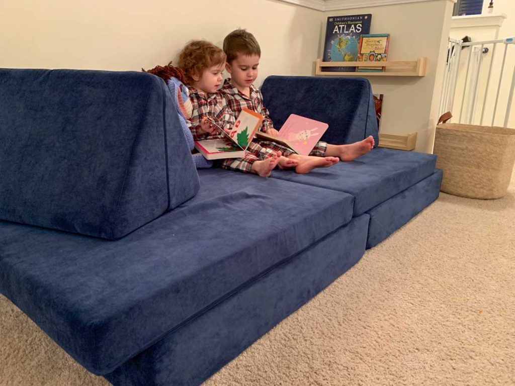 2 year old and her brother shown on nugget couch